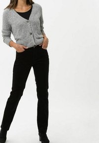Gray knitted cardigan with a V-neck and two brown buttons, paired with black corduroy pants. Smooth texture and fitted design.