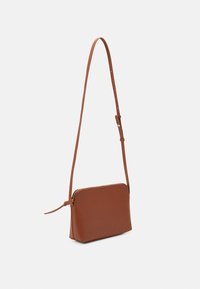 Ruskea nahkainen olkalaukku, jossa on ohut suorakulmainen muoto, kultainen vetoketju ja säädettävä hihna helppoa käyttöä varten. Tasainen pinta.