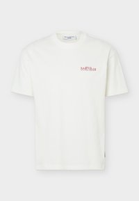 Λευκό κοντομάνικο T-shirt με στρογγυλή λαιμόκοψη, μικρό κόκκινο κείμενο "KRÄFTSKIVA" και επιπλέον μικρότερο κείμενο στο αριστερό στήθος.