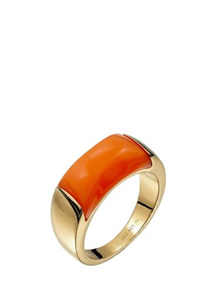 Guldring med en bred, slät orange hartsinläggning och graverade interna markeringar på vit bakgrund.