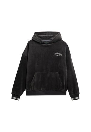 Sudadera de terciopelo negro con un bolsillo frontal, logo blanco de "Superdry" en el pecho izquierdo y puños acanalados a rayas. Cuenta con una capucha cómoda y un corte relajado.