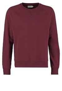 Burgundy sweatshirt med rund halsringning, långa raglanärmar och ribbade ärmslut och nederkant. Tillverkad av ett mjukt, texturerat tyg.