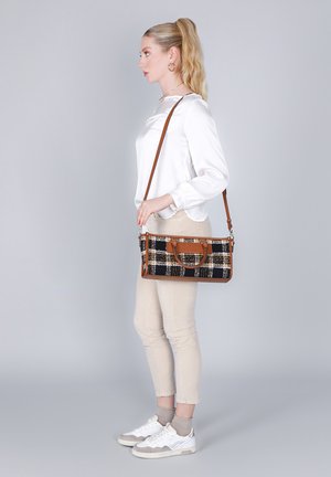 Borsa a mano a scacchi nera e beige con dettagli in pelle marrone, forma rettangolare, accessori in metallo e tracolla regolabile.