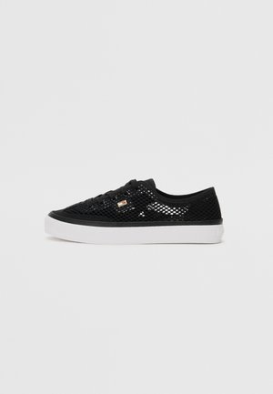 Baskets basses en mesh noir avec semelle en caoutchouc blanche et lacets noirs, vues de profil sur un fond uni.