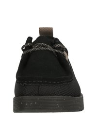 Black low-top shoes with a suede and mesh upper, featuring a textured sole, contrasting brown laces, and a pull tab at the back.