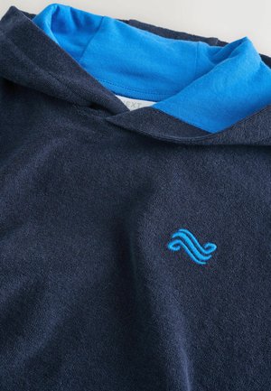 Marineblauer Kapuzenpullover mit hellblauer Innenfütterung und kleinem, blau gesticktem Wellenlogo auf der Vorderseite. Weicher, strukturierter Stoff.