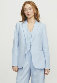 Hellblaues Anzug mit einem taillierten Blazer und passender Weste. Glattes Material, einreihig, mit zwei vorderen Taschen und Knopfverschlüssen.