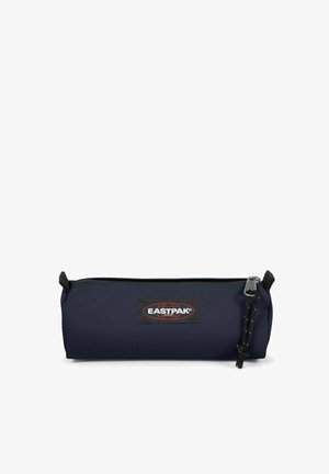 Trousse de couleur bleu marine fabriquée en tissu résistant, de forme cylindrique, dotée d'une fermeture éclair, d'un badge logo noir et d'une surface texturée.