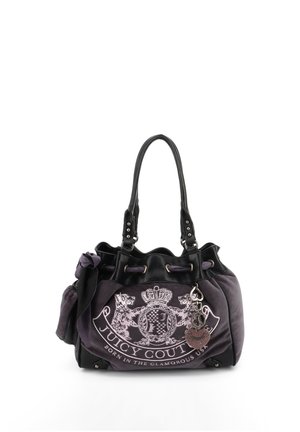 Dunkellila Juicy Couture Handtasche mit schwarzen Griffen, vorderem Wappenlogo und herzförmigem Anhänger vor weißem Hintergrund.