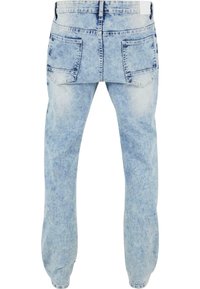 Jean en denim bleu clair avec une coupe décontractée, présentant une taille contrastante, des poches arrière et une texture délavée sur l'ensemble.