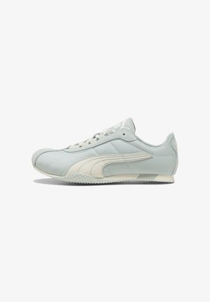Hellgrauer Low-Top-Sneaker mit weißem Puma-Logostreifen, Schnürung vorne, strukturierter Sohle und Veloursleder-Akzenten an Spitze und Ferse.