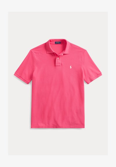 Polo majica s kratkimi rokavi v svetlo roza barvi, izdelana iz mehkega bombažnega materiala. Ima ovratnik, tri gumbe in majhen logotip na prsih.