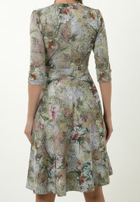 Blumenkleid mit Dreiviertelärmeln, tailliertem Oberteil, schwingendem Rock und einem strukturierten Stoff mit pastellfarbenen Blumenmustern.