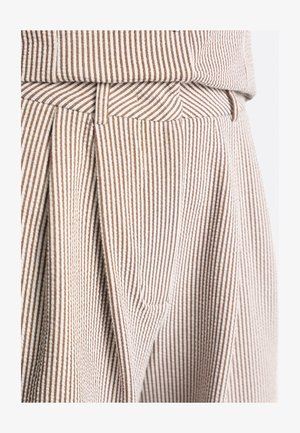 Nahaufnahme von beigefarbenen und braunen, vertikal gestreiften, plisseeartigen Hosen mit Gürtelschlaufen und passendem Bund.