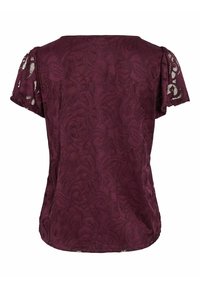 Top in pizzo bordeaux con maniche corte, motivo floreale, vestibilità leggermente ampia e bordi ondulati sottili lungo le maniche.
