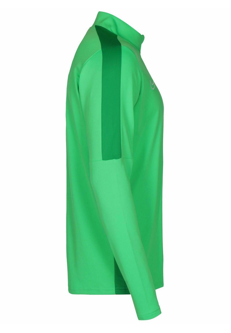Chemise de sport à manches longues verte avec col, présentant des panneaux latéraux verts plus foncés, une texture lisse et une coupe ajustée.