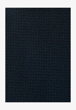 Texturovaná námořnická tkanina s mřížkovým vzorem, s rovnoměrně rozloženými malými čtverci, které vytvářejí hmatový povrch vhodný pro různé použití.