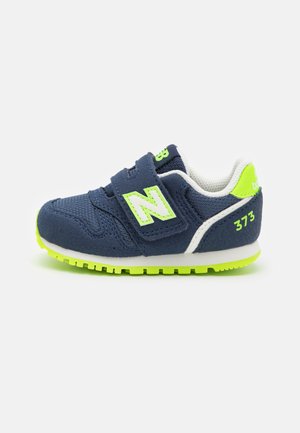 Navy blue toddler sneaker with neon green sole, strap, and accents, featuring velcro closure and "373" marking on heel.