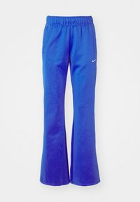 Flared athletic pants in bright blue, featuring an elastic waistband, two side pockets, and a small white logo on the front.