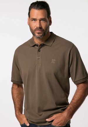 Polo marrón con cuello, mangas cortas y tapeta de tres botones. Presenta un discreto logotipo y una textura acanalada.