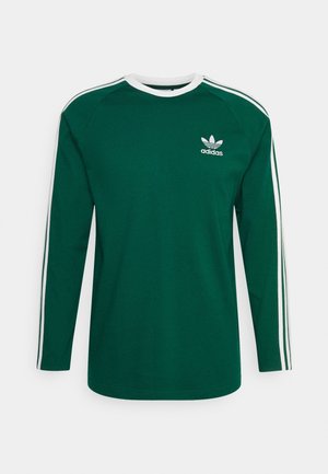 Grøn langærmet skjorte med hvid krave og tre hvide striber langs ærmerne. Har et Adidas-logo på venstre bryst.