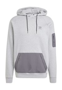 Šedá mikina s kapucí vyrobená z měkké tkaniny, s tmavě šedou přední kapsou, akcentovanou zipovou kapsou na rukávu a černými šňůrkami.