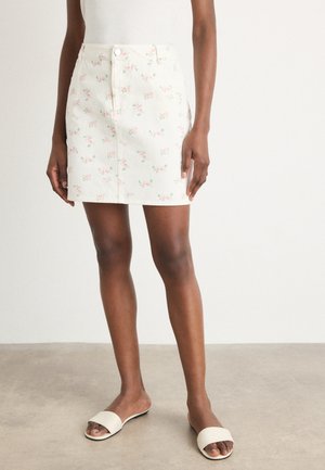 Blomstrete denimskjørt i lys krem med rosa blomster, med knappåpning foran og slim fit-design.