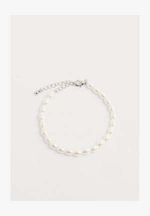 Pulsera con perlas blancas ovaladas, cierre de langosta plateado y cadena ajustable sobre fondo blanco.