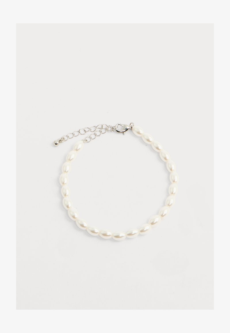 Apyrankė su ovalo formos baltais perlai ir sidabrine omaro segtuku bei reguliuojama grandinėle ant balto fono.