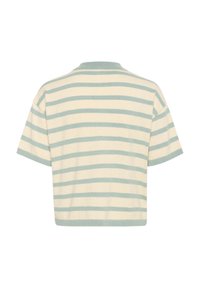 Kortärmad, beskuren polo i ljusbeige med horisontella tealrandar. Har en ribbad krage och en mjuk bomullstextur.