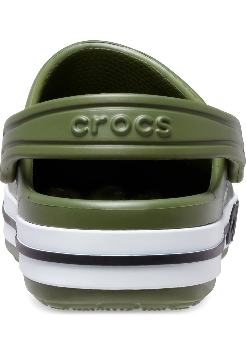 Sandale en plastique verte à enfiler avec une bride arrière, affichant une surface texturée, des rayures blanches et noires, et "crocs" embossé à l'arrière.