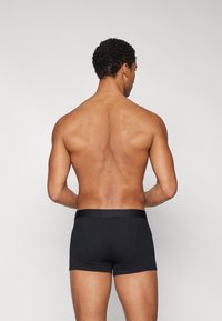 Black boxer briefs with a smooth texture, featuring a wide elastic waistband. The design is minimalistic, showcasing a close-fitting cut.
