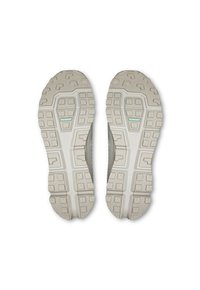 Gray athletic shoe soles with textured grip patterns. The outsole features varying shapes and a central blue accent for traction.