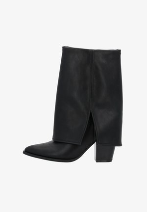 Botte en cuir noire mi-mollet avec bout pointu, talon bloc et un détail de patte avant superposée.