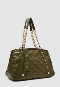 Borsa a tracolla trapuntata verde oliva con manici a catena in tonalità oro e accessori coordinati. Caratterizzata da una tasca con zip e un'etichetta personalizzata sul lato.