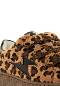 Sneaker con stampa leopardata e texture simile alla pelliccia, dotato di cinturini in velcro neri e suola in gomma a contrasto.