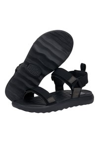 Sandale noire avec des sangles réglables, une semelle intérieure texturée et une semelle en caoutchouc ondulée. Comprend un logo sur la semelle et des accents sur le côté.