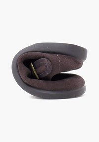 Zapato de ante marrón sin cordones con una suela de goma flexible, forma redondeada y banda elástica interior para un ajuste ceñido.