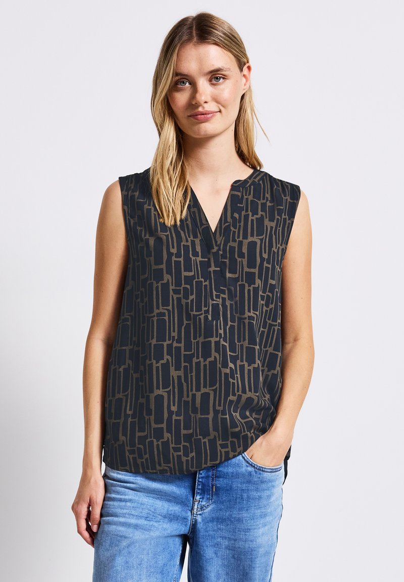 Ärmlös blus i mörk marinblå med ett abstrakt beige geometriskt mönster, med en V-ringning och en avslappnad passform. Mjuk tyg, avslappnad stil.