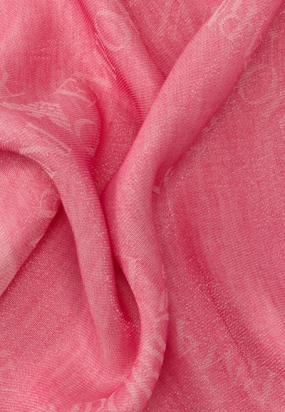 Απαλό, διάφανο ροζ ύφασμα με διακριτό υφαντό ανάγλυφο και απαλές πτυχώσεις που δημιουργούν παραλλαγές φωτός και σκιάς.