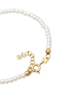 Weißes Perlenkette mit einem goldenen Verschluss und einer Kettenverlängerung. Enthält runde Perlen und ein goldfarbenes Akzentperle. Verschluss mit "AG925" gekennzeichnet.
