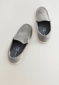 Graue Wildlederschlupfschuhe mit runder Zehenpartie, kontrastierenden weißen Nähten und einer strukturierten Innensohle mit dem Markennamen.
