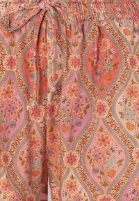 Drawstring waistband fabric with pink, orange, and beige floral pattern featuring large blossoms and greenery within wavy vertical borders.