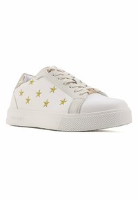 Baskets en cuir blanc avec des motifs d'étoiles dorées, fermeture à lacets et semelle en caoutchouc texturée. Accents métalliques à l'arrière.