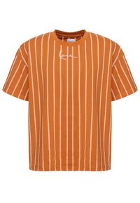 Oransje t-skjorte med korte ermer, hvite vertikale striper, rund halslinning og et lite logodesign på forsiden. Mykt bomullsmateriale.