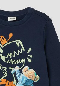 Granatowy sweatshirt z grafikiem kreskówkowego dinozaura w jasnej zieleni oraz postacią niedźwiedzia trzymającą puszkę sprayu.