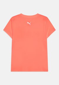 Camiseta deportiva color coral, de manga corta, con textura suave, que presenta un logo blanco en la parte trasera y un diseño clásico de cuello redondo.