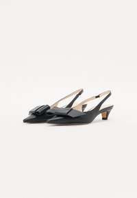 Sorte skinn slingback-sko med spiss tå og en stor sløyfe detalj. Litt hevet hæl med en glatt tekstur og minimale designaksenter.