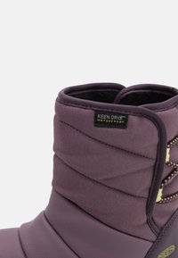 Fioletowe wodoodporne buty z teksturowaną powierzchnią, szytymi detalami i metką KEEN.DRY™. Wysokiej jakości design z dopasowanym, pikowanym wyglądem.