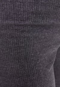 Grå ribbat tyg med en texturerad yta, som har smala vertikala linjer som skapar ett subtilt mönster genom hela.